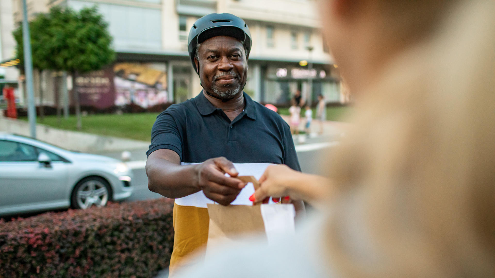 Senior African Delivery Man Delivering Bags With Food To Customer